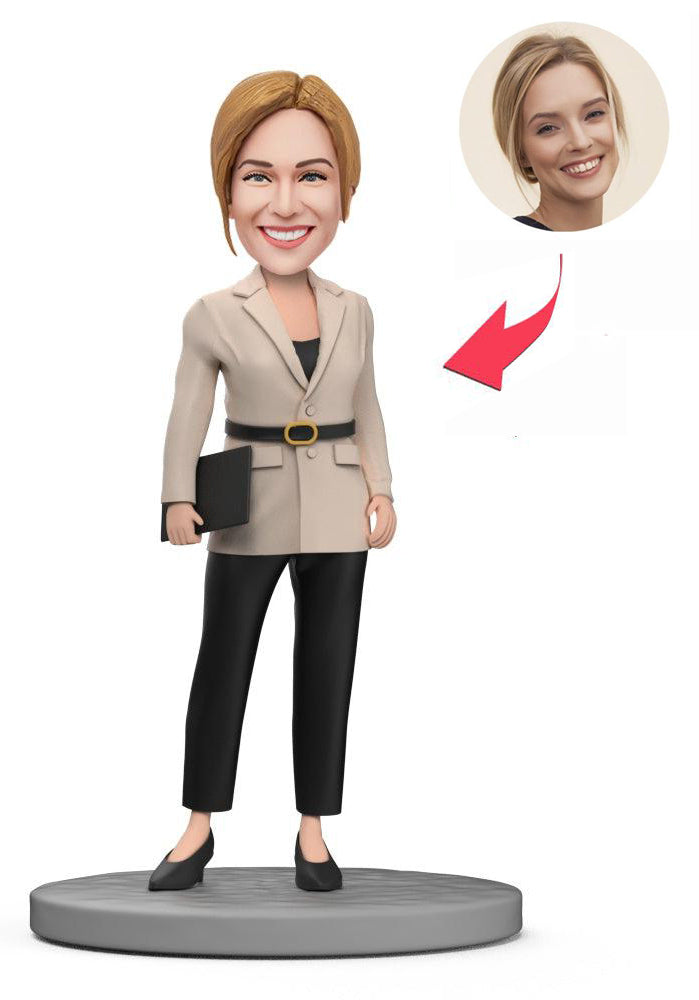 A custom figurine of a woman in a beige blazer, shown beside the photograph it was modelled on.